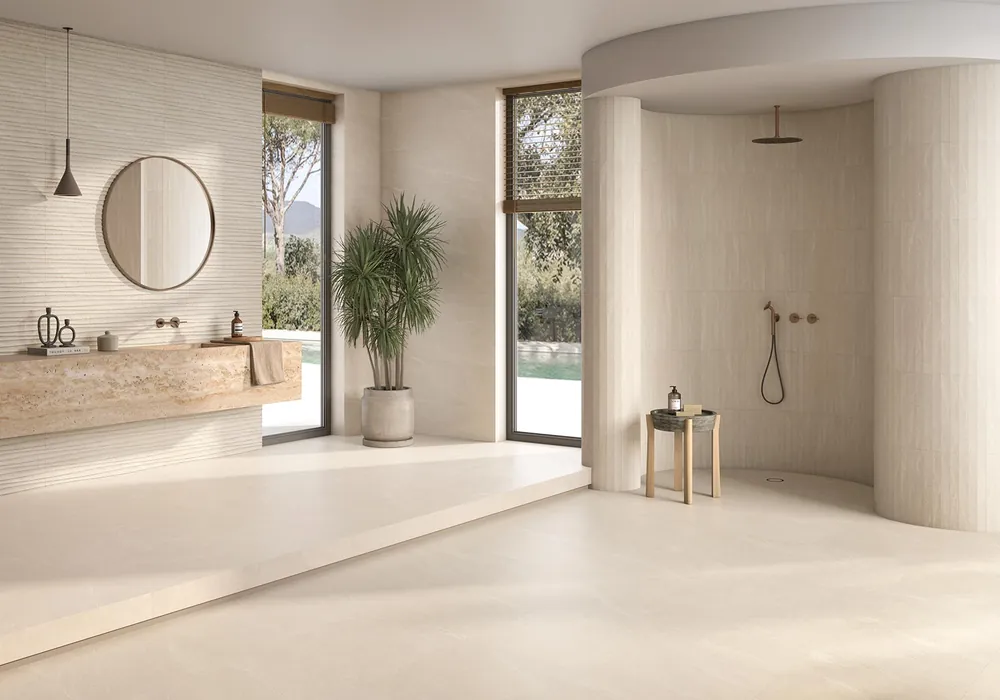 Bad in warmem Creme mit Kalksteinoptik an Wand, Boden und runder Dusche